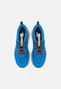 Niebieskie buty sportowe z siateczkową cholewką, szarymi akcentami i czarnymi sznurowadłami. Posiadają czerwoną grafikę w postaci logo swoosh oraz wyściełaną podeszwę dla komfortu.