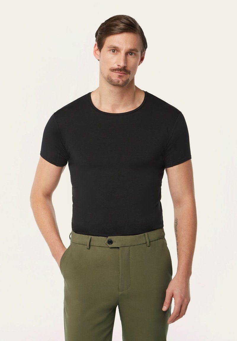 Black short-sleeve t-shirt with a round neckline, paired with green trousers. T-shirt has a smooth texture and fitted design.