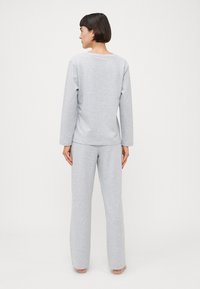 Grå bomulls loungewear-sett med langermet topp med rund hals og løstsittende bukser med rette ben, myk tekstur.