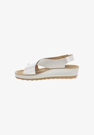 Sandalia con cuña blanca con tiras anchas cruzadas y una correa trasera ajustable, con plantilla acolchada en tono marrón claro y suela de goma texturizada.