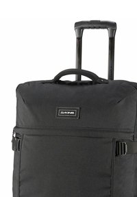 Zaino con ruote nere, dotato di un manico robusto, tessuto resistente, tasca frontale con zip e patch brandizzato, progettato per il trasporto e la conservazione.