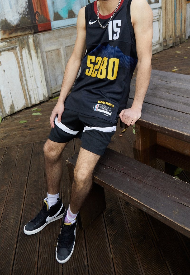 Czarna koszulka do koszykówki z białymi i żółtymi akcentami, z nadrukiem "5280" i "DENVER NUGGETS", w zestawie z czarnymi szortami i trampkami.