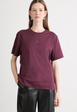 Bordo pamučna majica s kratkim rukavima i okruglim izrezom, sa malim izvezenim logotipom na središnjem dijelu.
