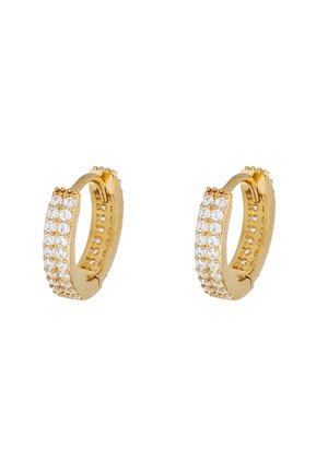 Boucles d'oreilles créoles en or avec une surface texturée et bordées de cristaux clairs. Elles ont une finition lisse et polie ainsi qu'une forme circulaire.