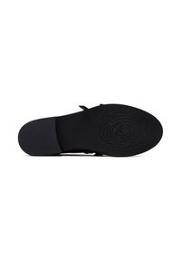Zwarte platte zool schoen met een zachte textuur en een gladde afwerking; heeft een cirkelpatroon op de outsole en een eenvoudig ontwerp.