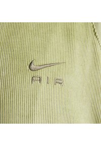Lys grønne fløjlstof med lodrette ribber; har broderet brunt Nike-logo og "AIR" under det.
