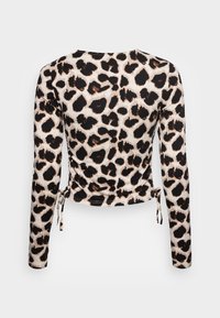 Langsleeve shirt in een luipaardprint met tinten zwart en bruin op een roomkleurige achtergrond, met trekkoorddetails aan de zijkanten.