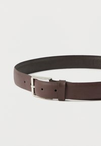 Ceinture en cuir marron à texture lisse, dotée d'une boucle en métal argenté et de trous réglables pour un ajustement personnalisé.