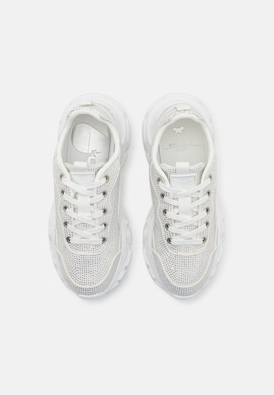 Pantofi sport albi cu partea superioară din plasă, vârf rotund, talpă groasă albă și șireturi tradiționale. Prezintă un logo discret pe limbă și călcâi.
