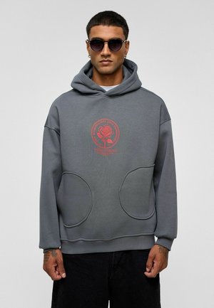 Grijze hoodie met een grote voorzak, een capuchon met trekkoord en een rode roosgrafiek op de borst. Heeft een ontspannen pasvorm en een zachte textuur.