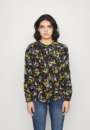 Blusa preta de manga longa com um padrão floral em amarelo, azul e branco, com um decote redondo e uma pala frontal com botões.