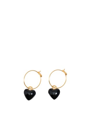 Pendientes de aro de oro, cada uno con un pequeño colgante en forma de corazón negro colgando en la parte inferior.