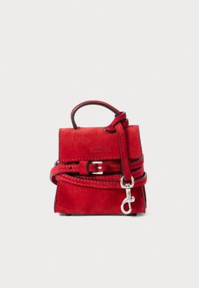 Sac à main en suède rouge avec une petite poignée, une sangle amovible et un détail de boucle. Il présente une finition texturée et un logo embossé sur le devant.