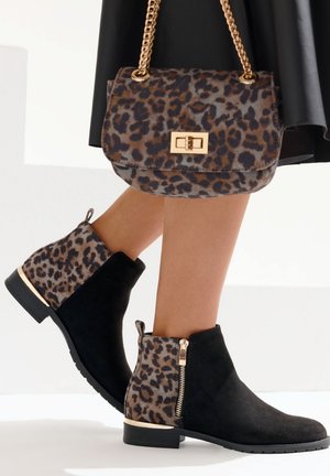 Black suede ankle boots with leopard print accents, gold zipper, and a flat sole, paired with a matching leopard print handbag.