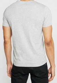 Grau kurzärmliges T-Shirt mit Rundhalsausschnitt, aus weichem Baumwollstoff gefertigt, mit glatter Textur und schmaler Passform im Rücken.