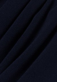 Marineblauer Strickstoff mit gerippter Textur, der glatte, gleichmäßige Linien und einen leichten Glanz aufweist, teilweise drapiert, um Tiefe und Dimension zu zeigen.