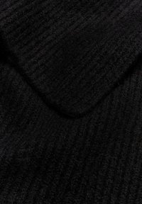 Tessuto nero a maglia con una texture a coste, con una finitura morbida e leggermente pelosa, che enfatizza la sua profondità e calore.