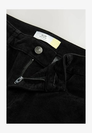 Čierne semišové slim-fit nohavice s stredne vysokým pásom, s rozopínaním na zips, kovovým gombíkom a viditeľným štítkom s pokynmi na údržbu.