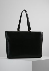 Zwarte leren handtas met twee afgeronde handvatten aan de bovenkant, rechthoekige vorm, gladde textuur en minimalistisch ontwerp. Geen zichtbare patronen of metalen details.