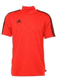 Kirkkaanpunainen Adidas lyhythihainen urheilupaita, jossa musta logo rinnassa ja mustat raidat hartioiden ja hihojen kohdalla.