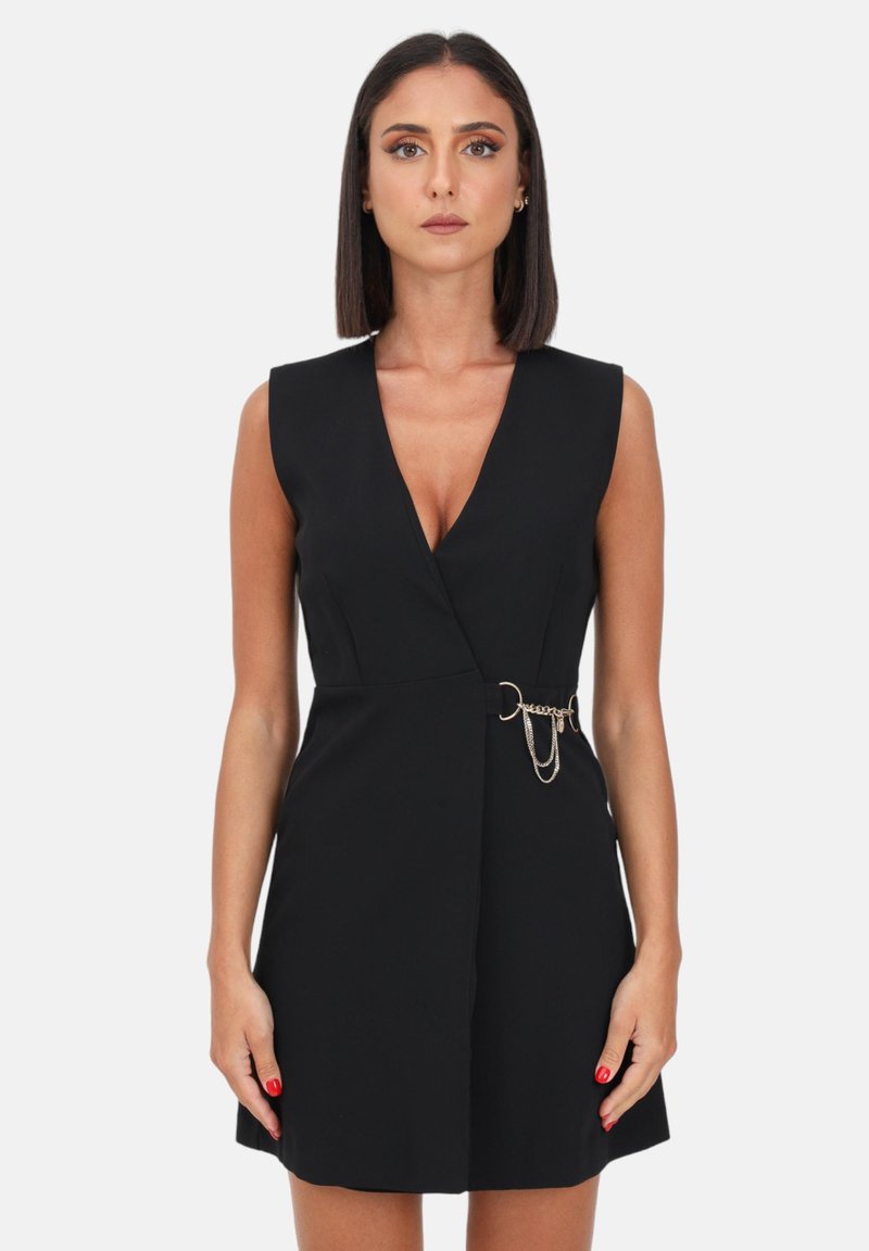 Schwarzes Kleid mit tiefem V-Ausschnitt, ärmellosem Design und einem goldenen Kettenakzent an der Taille. Glattes Material mit körpernaher Silhouette.