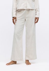 Lichtbeige wijde broek van textiel met een hoge taille en zonder zichtbare sluitingen, gecombineerd met een bijpassend top.