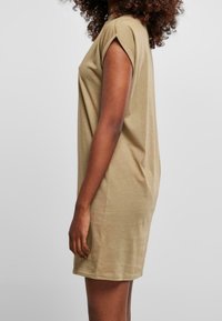 Khaki oversize sukienka wykonana z miękkiego materiału, z krótkimi rękawami i luźnym krojem. Gładka tekstura, do kolan.