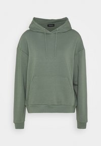 Sudadera verde de gran tamaño con bolsillo canguro en el frente, capucha con cordones y puños y dobladillo acanalados, mostrada sobre fondo blanco.