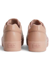 Sneaker in pelle rosa chiaro con suola in gomma testurizzata, dotate del logo Calvin Klein Jeans sul tallone e design arrotondato.