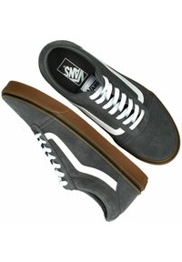 Zapatillas de ante gris con rayas laterales blancas, suelas de goma marrones y cordones blancos. Presentan un collar acolchado y el logo clásico de Vans en la plantilla.