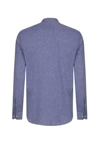 Camisa de manga larga, con botones, en una tela texturada de color azul claro. Presenta un collar estándar y puños con botones. Dobladillo redondeado.