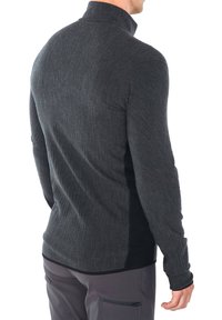 Pullover lungo grigio scuro con maniche lunghe e colletto alto, tessuto testurizzato e pannelli laterali neri a contrasto; design aderente con aperture per il pollice.