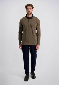 Langarm polo shirt in bruin textuurstof met een marineblauwe kraag, voorzien van een knoopsluiting en een borstzak, gecombineerd met marineblauwe broek.