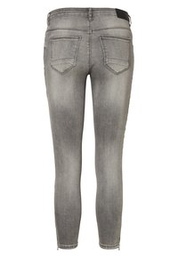 Jeans skinny em denim cinza desbotado. Apresenta dois bolsos traseiros, detalhes cosidos e fechos de correr nos punhos. Textura suave e corte justo.