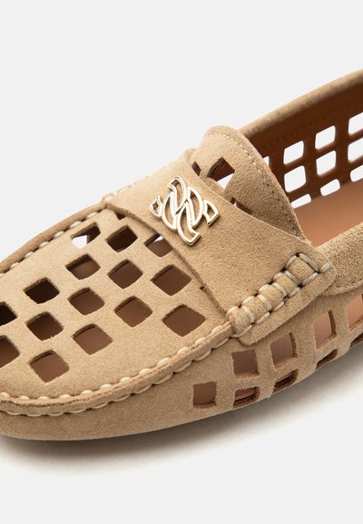 Μπεζ μοκασίνι από σουέτ με τετράγωνο μοτίβο κοψίματος, ραμμένες λεπτομέρειες και χρυσό διακοσμητικό λογότυπο στο μπροστινό λουράκι.
