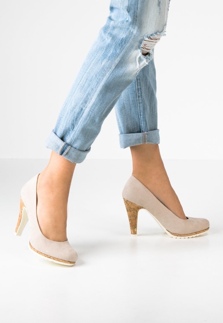 Des escarpins en suède beige avec des talons en liège, bout rond et légère plateforme. Portés avec un jean déchiré léger bleu retroussé.