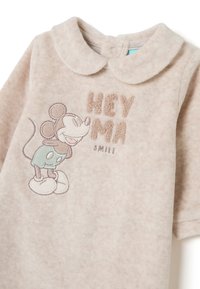 Pijama de felpa color beige claro con un cuello redondo, que presenta un diseño bordado de Mickey Mouse y el texto "HEY MA SMILE" en marrón.