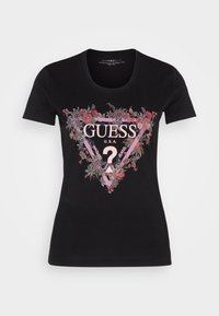 Černé bavlněné tričko s trojúhelníkovým květinovým designem. „GUESS® U.S.A.“ vytištěno uprostřed s růžovými akcenty a detailem otazníku.