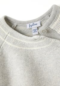 Helles graues Kurzarm-Pullover mit strukturiertem Strick. Mit Rundhalsausschnitt, Knopfverschluss und einem Pflegeetikett, das die Größe 3-6 Monate angibt.