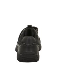 Scarpa sportiva nera vista da dietro, dotata di una suola testurizzata, colletto imbottito e linguetta di estrazione su sfondo bianco.