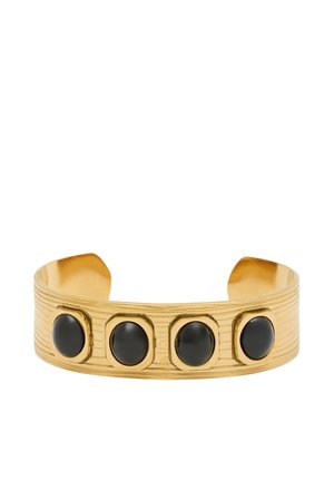 Bracciale a polsino d'oro con tre accenti in pietra nera, superficie testurizzata e bordi lisci. Il design è audace e lineare.