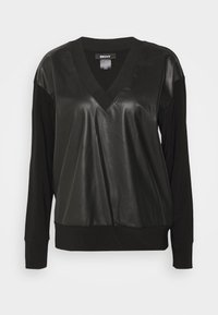 Schwarzes Oberteil mit V-Ausschnitt-Design, das eine lederähnliche Vorderseite und weiche Stoffärmel aufweist. Gerippte Bündchen und Bündchen an der Taille, lässiger Stil.