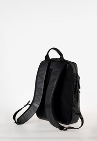 Zaino nero realizzato con materiali in tessuto e pelle, dotato di spallacci imbottiti, una tasca laterale con zip e un design elegante e angolare.