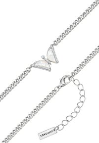 Bracciale in argento con pendente a forma di farfalla, ali in madreperla e dettagli simili a diamanti. Chiusura regolabile con etichetta del marchio.