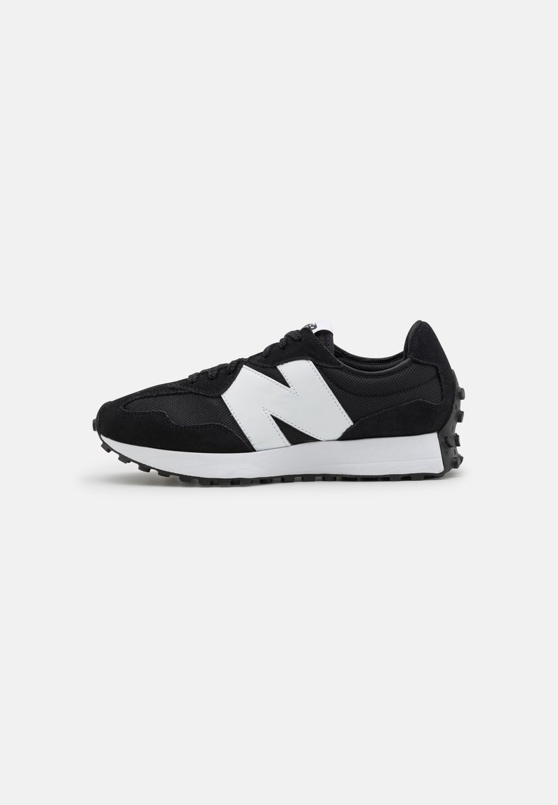 Baskets New Balance noir et blanc avec grand logo N blanc, dessus en mesh noir et en suède, semelle blanche avec motif d'usure noir sur fond gris.