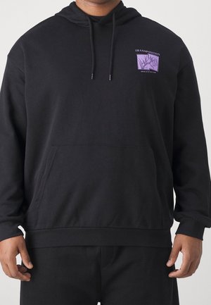 Zwarte hoodie met voorkantzak en trekkoorden, met een paarse vierkante afbeelding op de linkerborst met bloemmotief en tekst "TRANSPOSITION, GROW WITH THE FLOW."