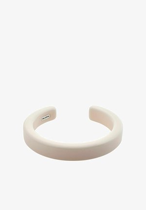 Breiter, glatter Armreif aus matter, hellrosafarbener Materie. Hat eine kreisförmige Form mit abgerundeten Kanten und einem kleinen Logo im Inneren.