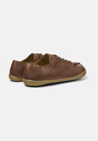 Sneaker in pelle marrone con punta rotonda, design con lacci e suola in gomma. Accentuate con tallone testurizzato e branding discreto sul retro.
