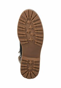 Suela de bota negra con un patrón texturizado y acanalado, además de diseños en forma de estrella. Hecha de goma en color marrón claro. Talla 37 indicada.