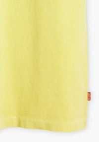 Yellow t-shirt made of cotton, featuring a soft texture and a straight cut. Includes a small red brand tag stitched at the hem.